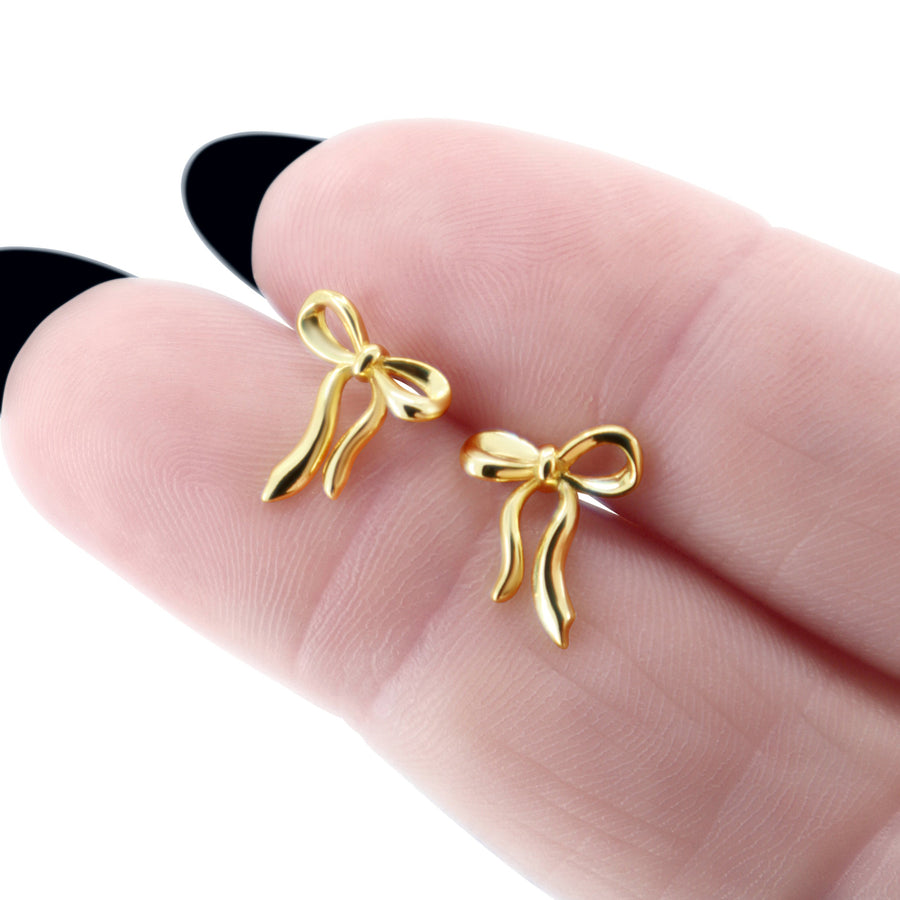 Schleifen Ohrstecker aus 14K vergoldetem 925 Silber, alternativer und leicht Gothic-inspirierter Schmuck, zarte goldene Ohrringe mit Schleifen-Design für Damen von Pour la Rebelle.